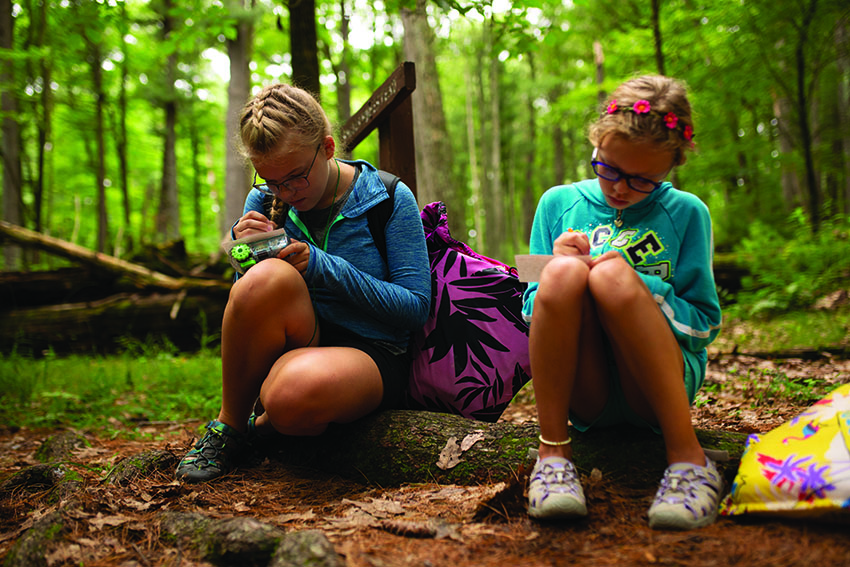 Two students recording scientific observations at Upham Woods Outdoor Learning Center.