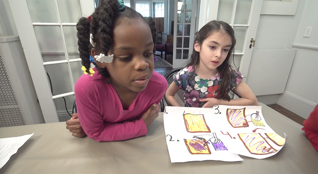 Two girls discuss the sequence of steps for making a peanut butter and jelly sandwich.
