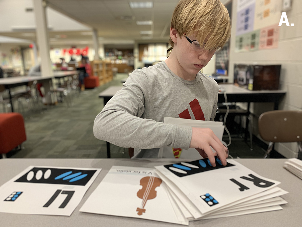 A middle school student preps pages for binding into a new tactile alphabet book designed to teach young students with visual impairments how to use a Perkins Brailler.