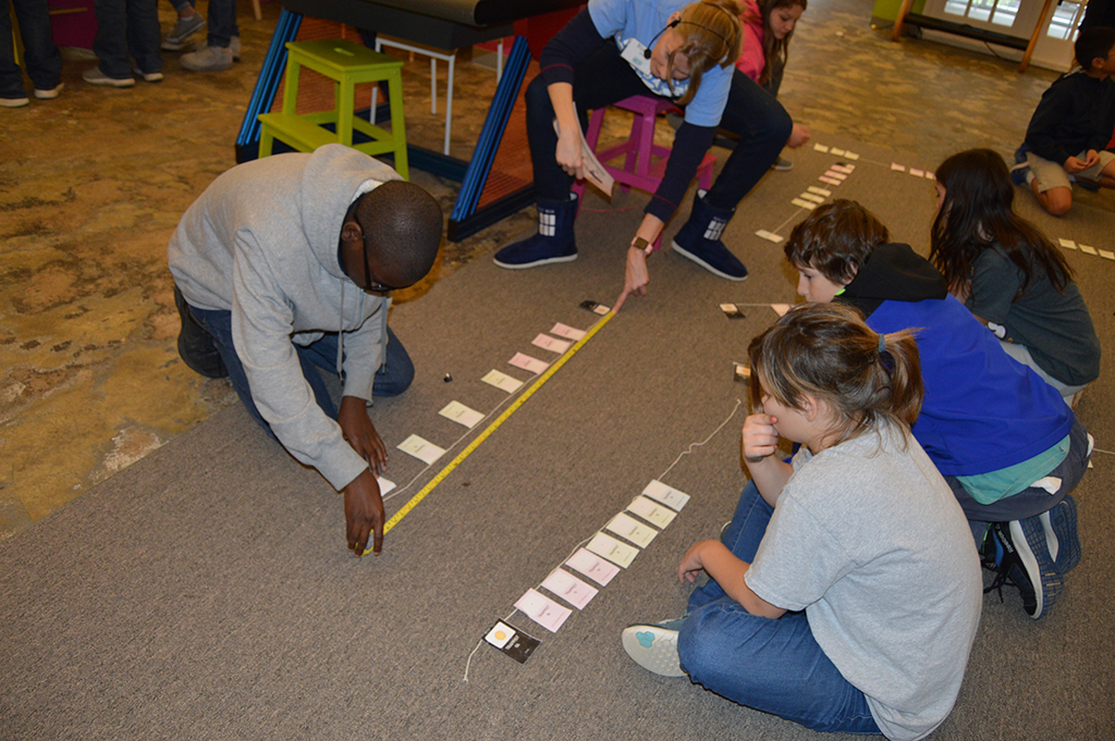 Students compare our solar system to the TRAPPIST-1 planetary system during a field trip to Pensacola MESS Hall.