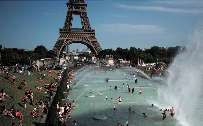 People cool off in front of the Eiffel Tower in Paris during a heat wave in 2019 