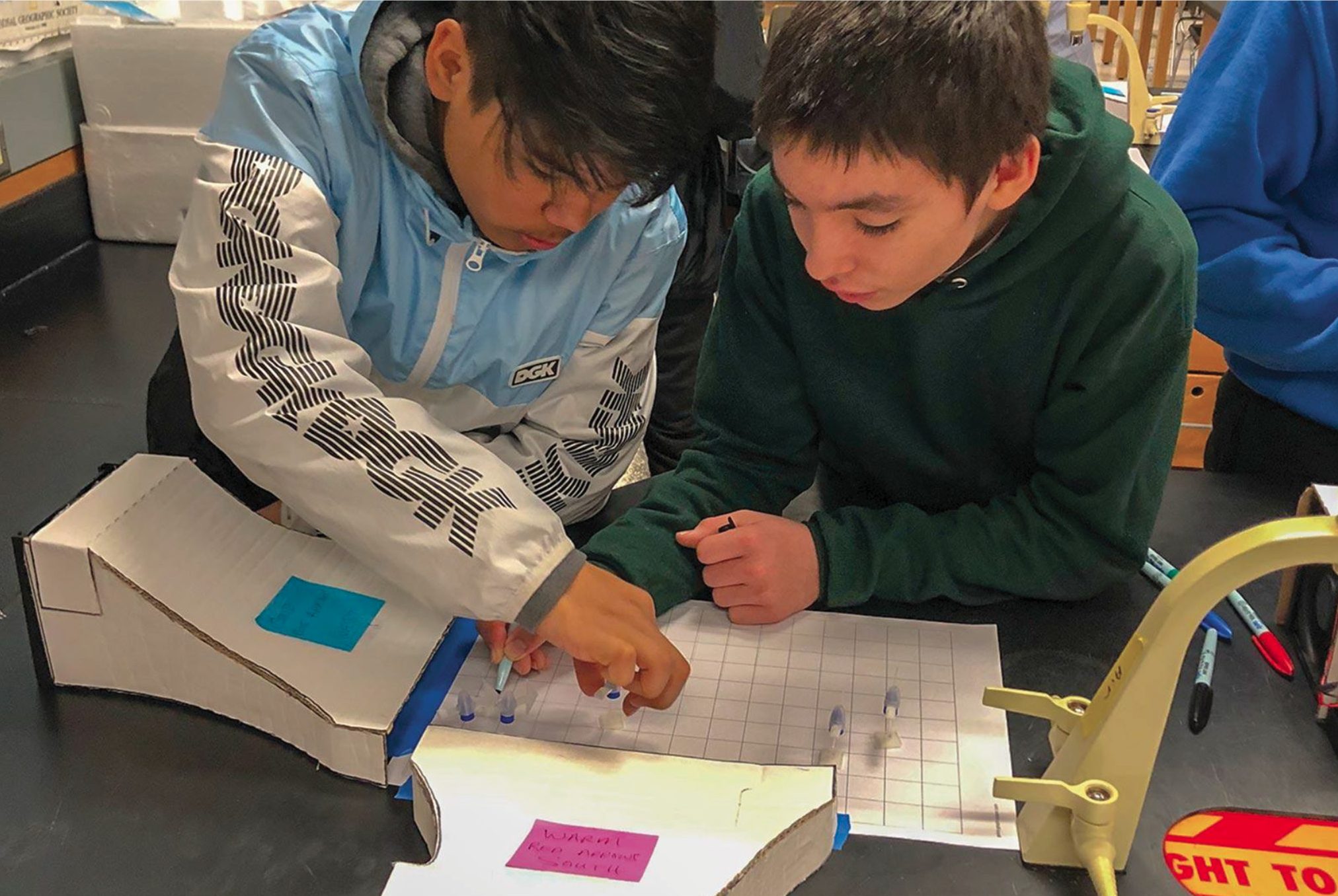 Students use a wind tunnel to investigate wind direction.