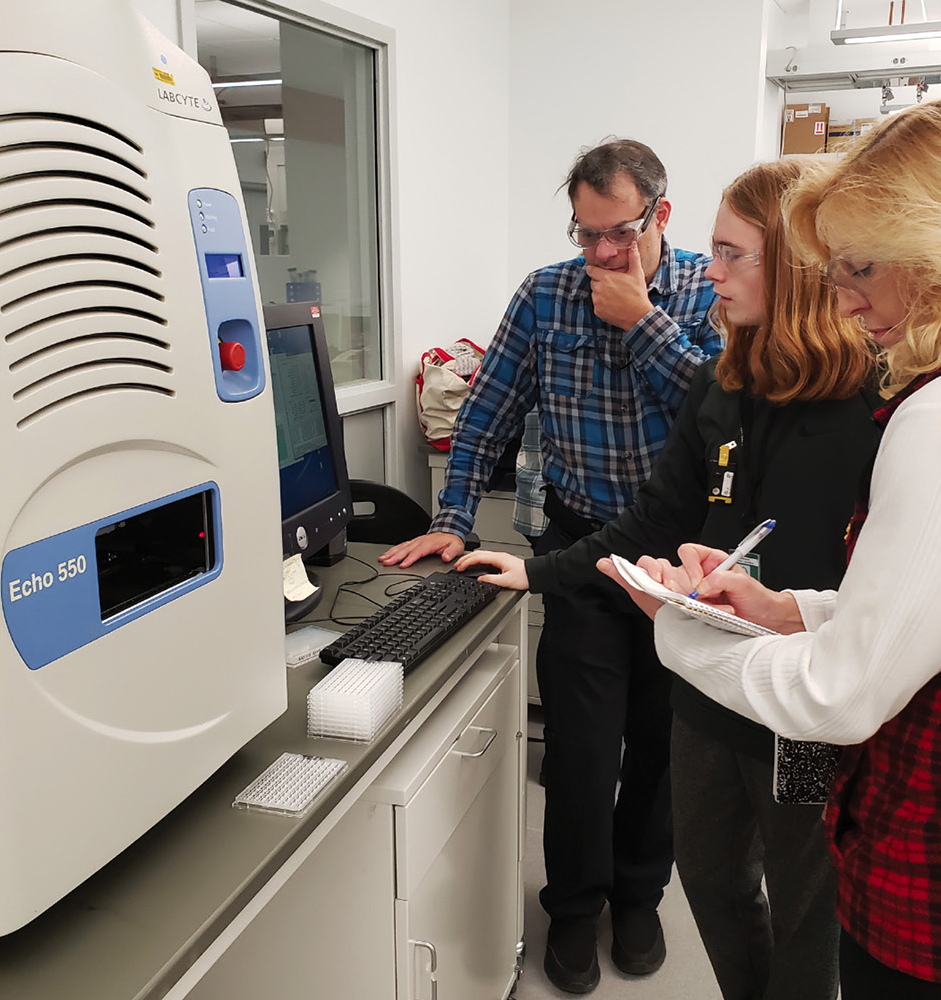 SPARK student Gavin Stumpf and teacher are trained by a BNL mentor scientist to use a protein crystallization robot in the NSLS II biological sample preparation laboratory. Students and teachers followed all required safety protocols and training for use of the instruments in the laboratory.