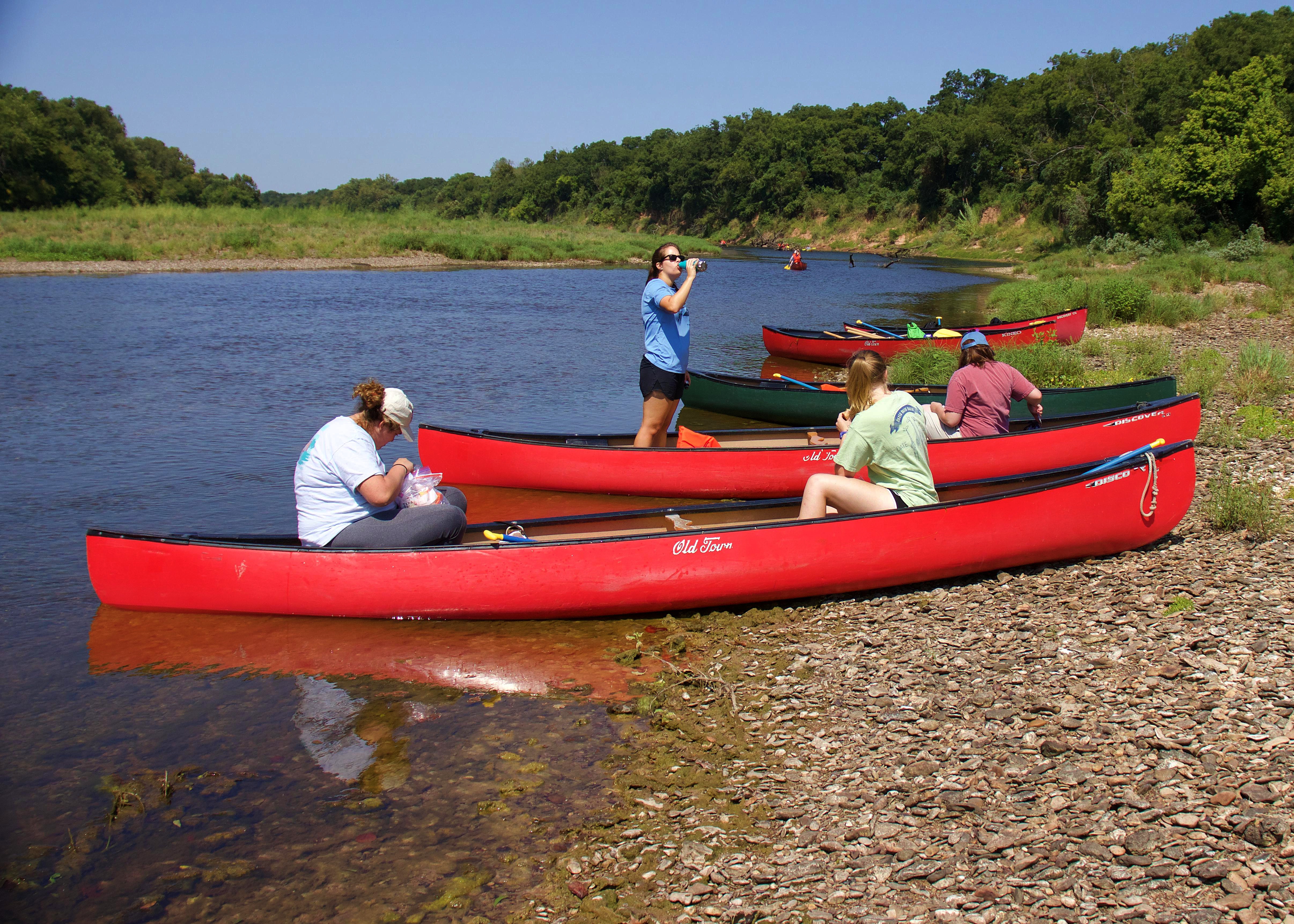 Students take a break during the eight-mile river canoe trip.