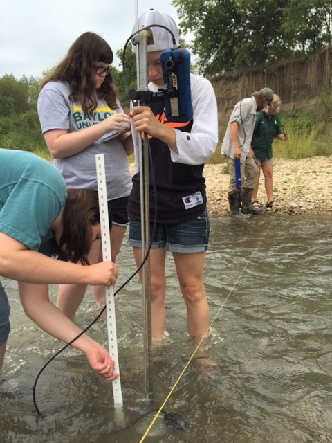 Students gather river stream flow data. 