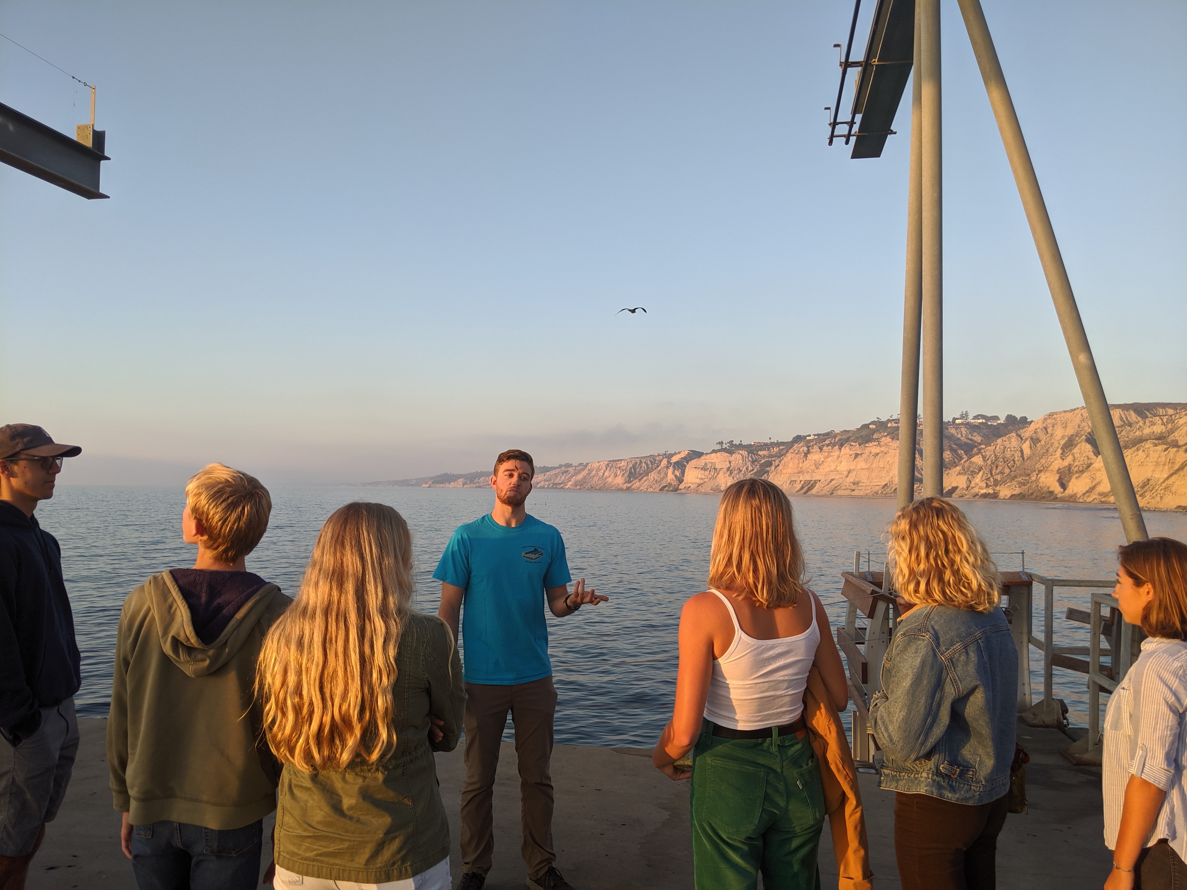 Scripps PhD candidate and previous SCOPE coordinator Wiley Wolfe leads students on a tour of the Ellen Browning Scripps Memorial Pier.