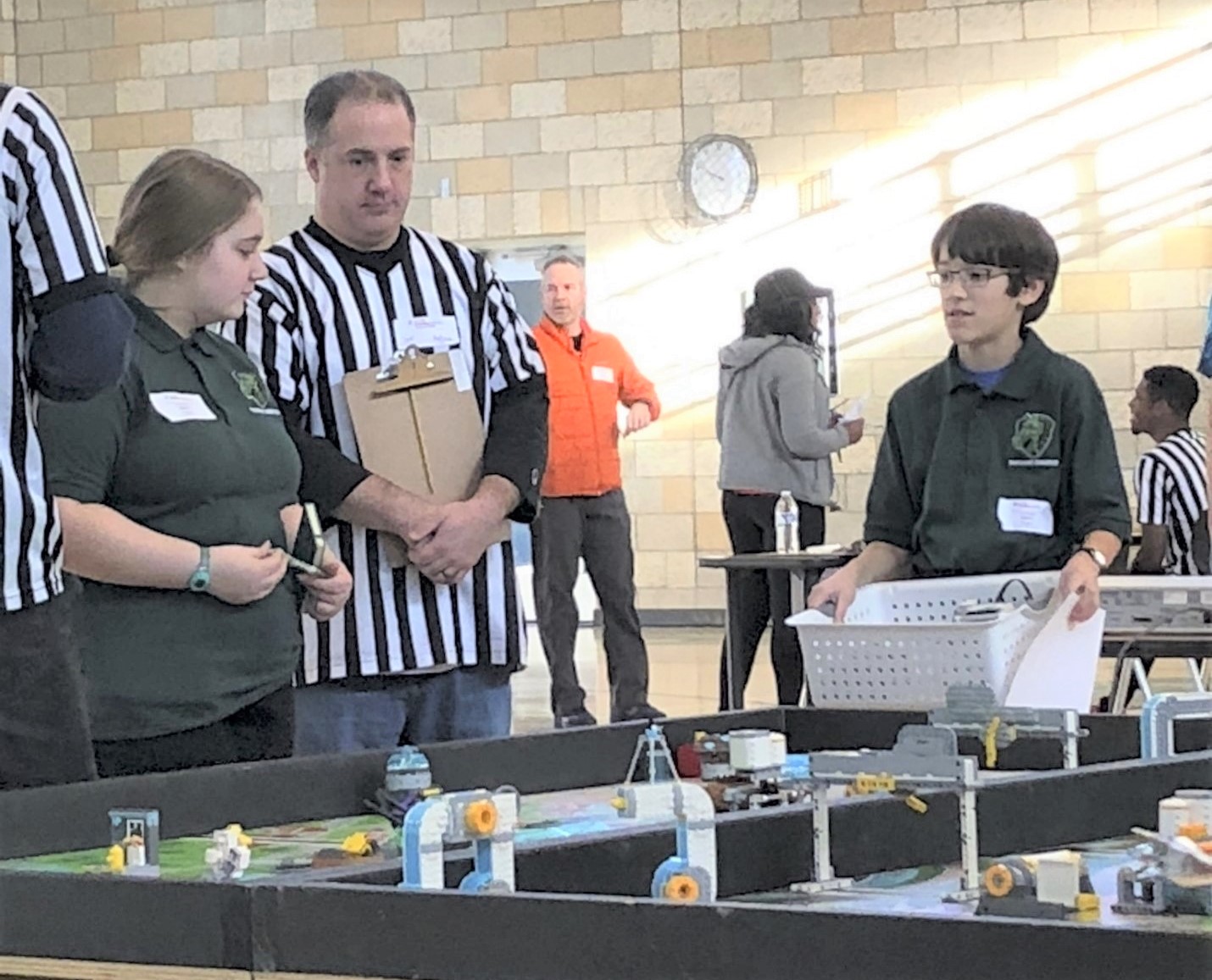 Parkrose youth from the SUN afterschool MESA Club explain their Robotics design to a referee at a citywide competition.