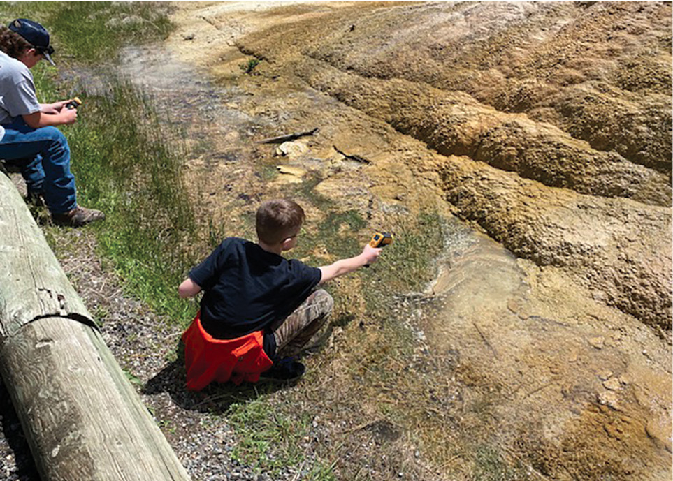 Careful to protect and preserve the integrity of Orange Spring Mound hot spring, a student uses a digital temperature gun to determine the water’s temperature.