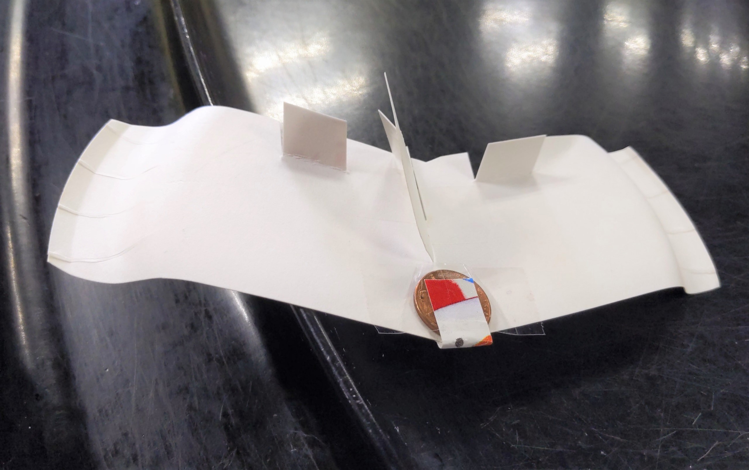 Figure 5. An image of a constructed foam plate glider-9. Students modify the various flaps on the plane throughout the third VFT session to test how forces influence the distance traveled by the foam plate glider-9.