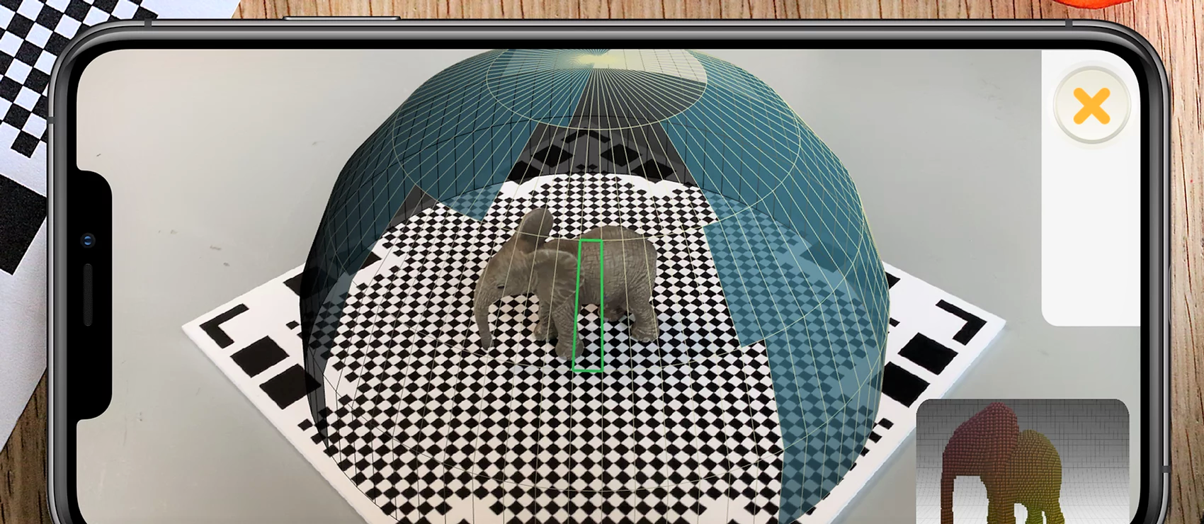 A screenshot of the scanning process within the Qlone app. Each slice in the hemisphere represents a single capture of the model. A slice becomes transparent once the image has been taken successfully. A capture is only successful when the software determines the angle and distance from the model are appropriate. This process is done twice, flipping the model between scans so the bottom surface is visible.