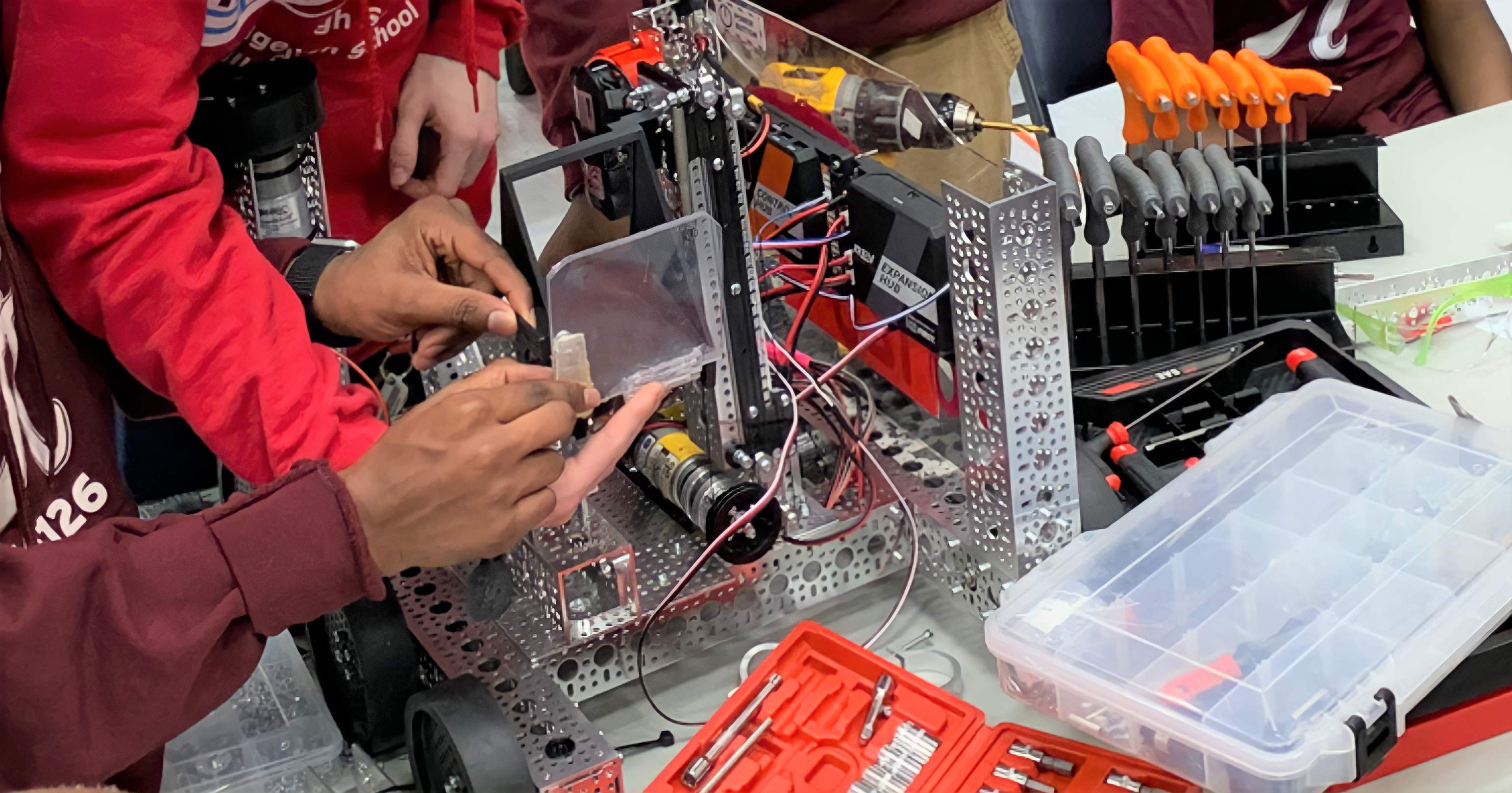 Students collaborating to build robot for first tech challenge 