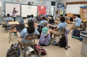 Science laboratory technician offering one of the workshops to fifth-grade students.