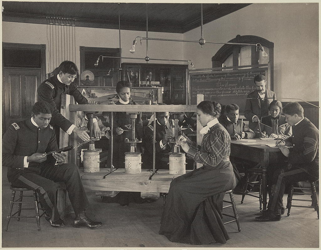 This image of “The cheese press screw - students studying agricultural sciences, Hampton Institute, Hampton, Virginia,” is available at www.loc.gov/resource/ppmsc.04892. It is part of the Johnston (Frances Benjamin) Collection at the Library of Congress. The collection contains about 20,000 photographic prints as well as 3,700 glass and film negatives; more than 3,000 photographs are available at www.loc.gov/collections/frances-benjamin-johnston. Additional photographs of classrooms can be found within the 