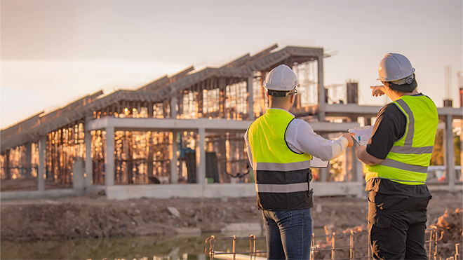 two engineers overlook a construction project