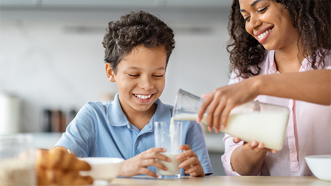 mother pouring milk in a glass for her son