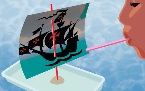 Child blows on a the boat sail made in the activity.