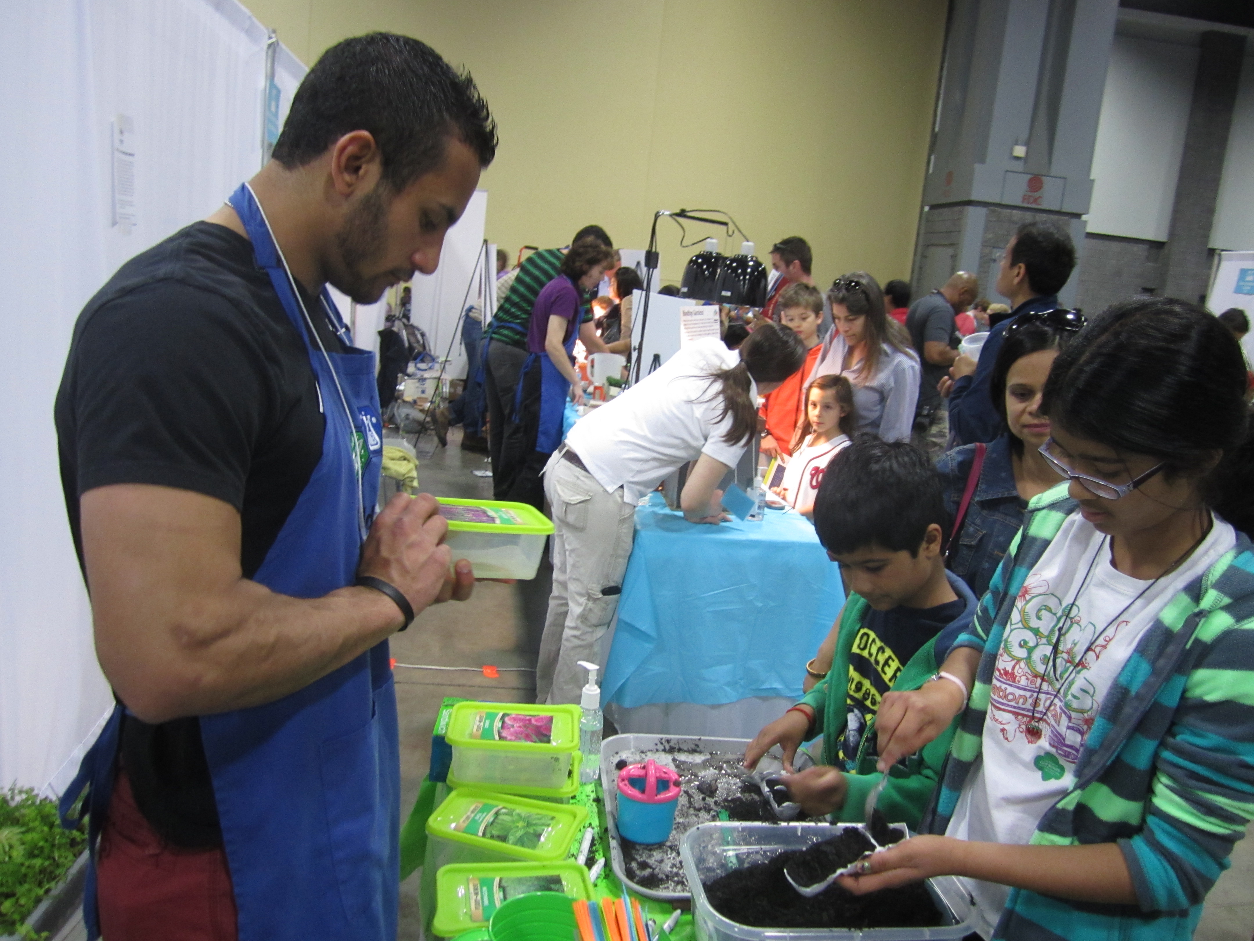 Volunteers plant herb seeds with children at the USA Festival of Science & Engineering