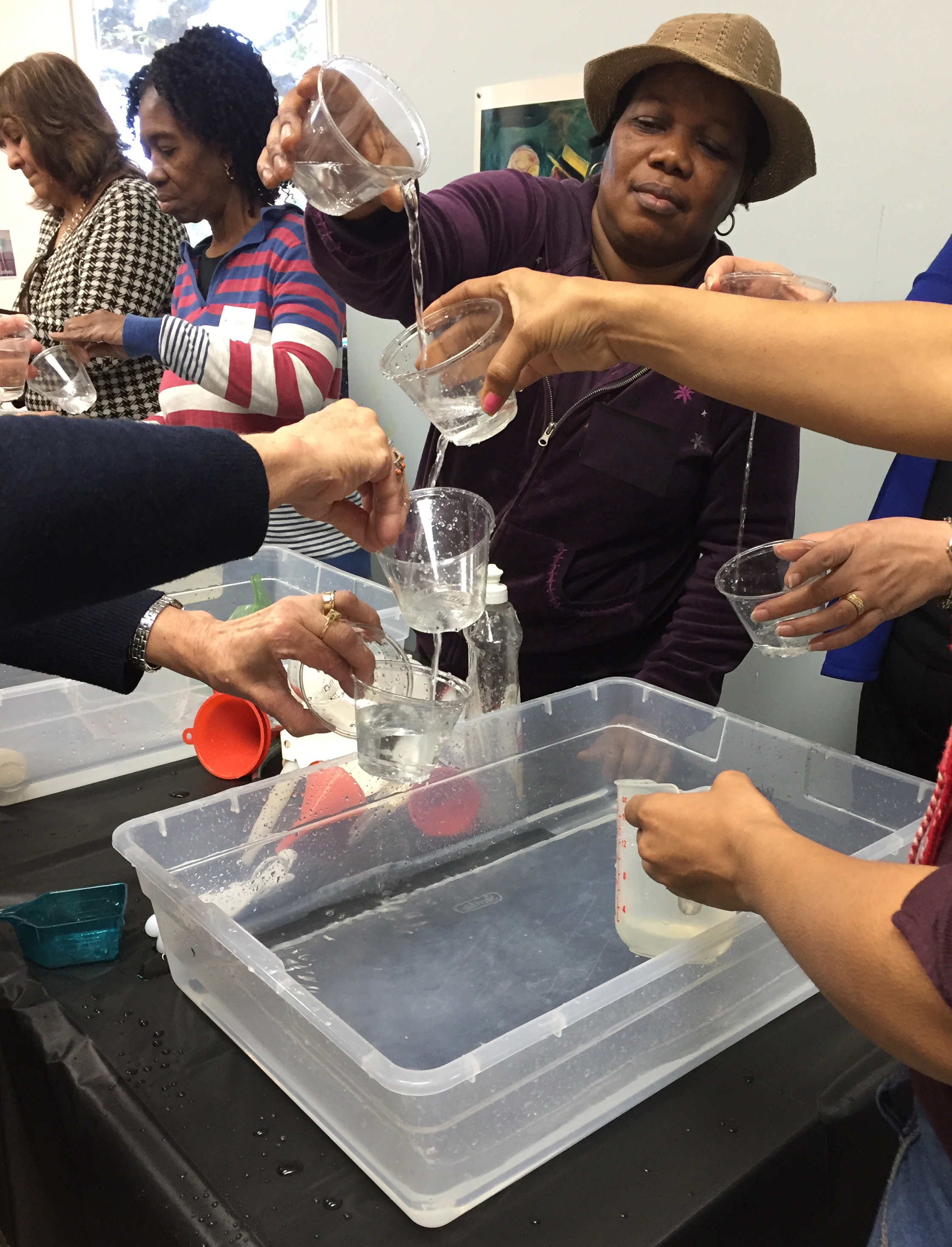 Exploring water flow using cups with various holes.