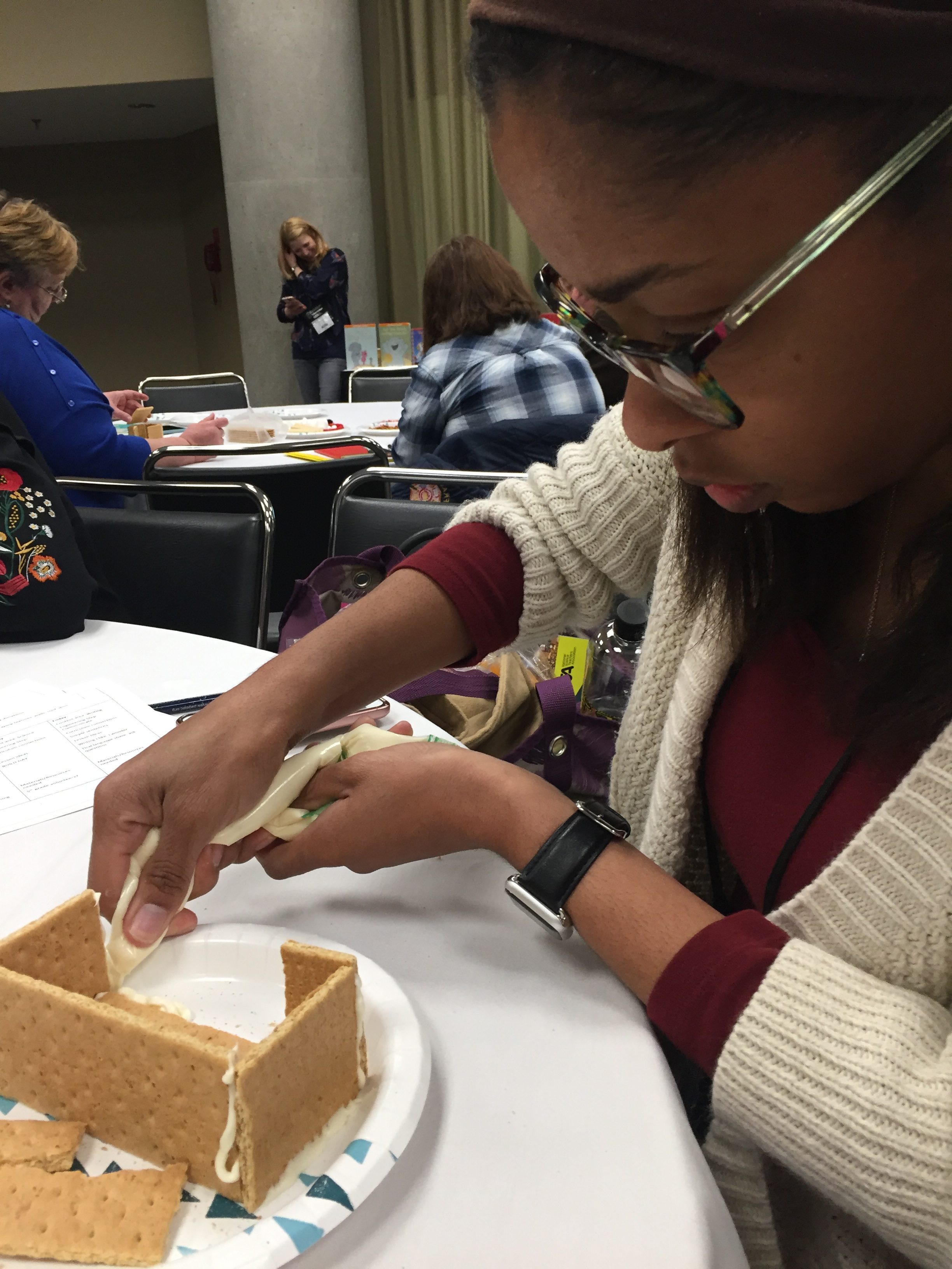 Participant applying icing to hold graham crackers together.