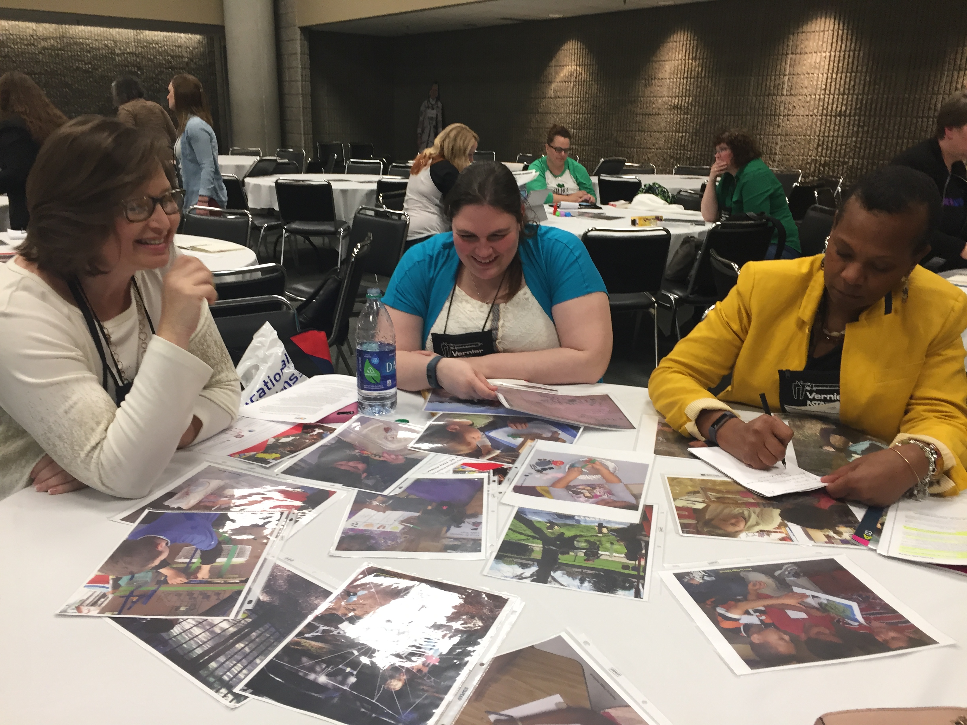 Participants sitting at a table, looking at photos.