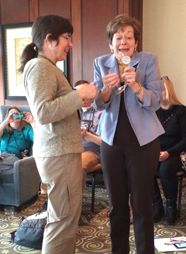 Linda Froschauer showing excitement as she receives the "Golden Hand Lens" award from the NAEYC ECSIF.