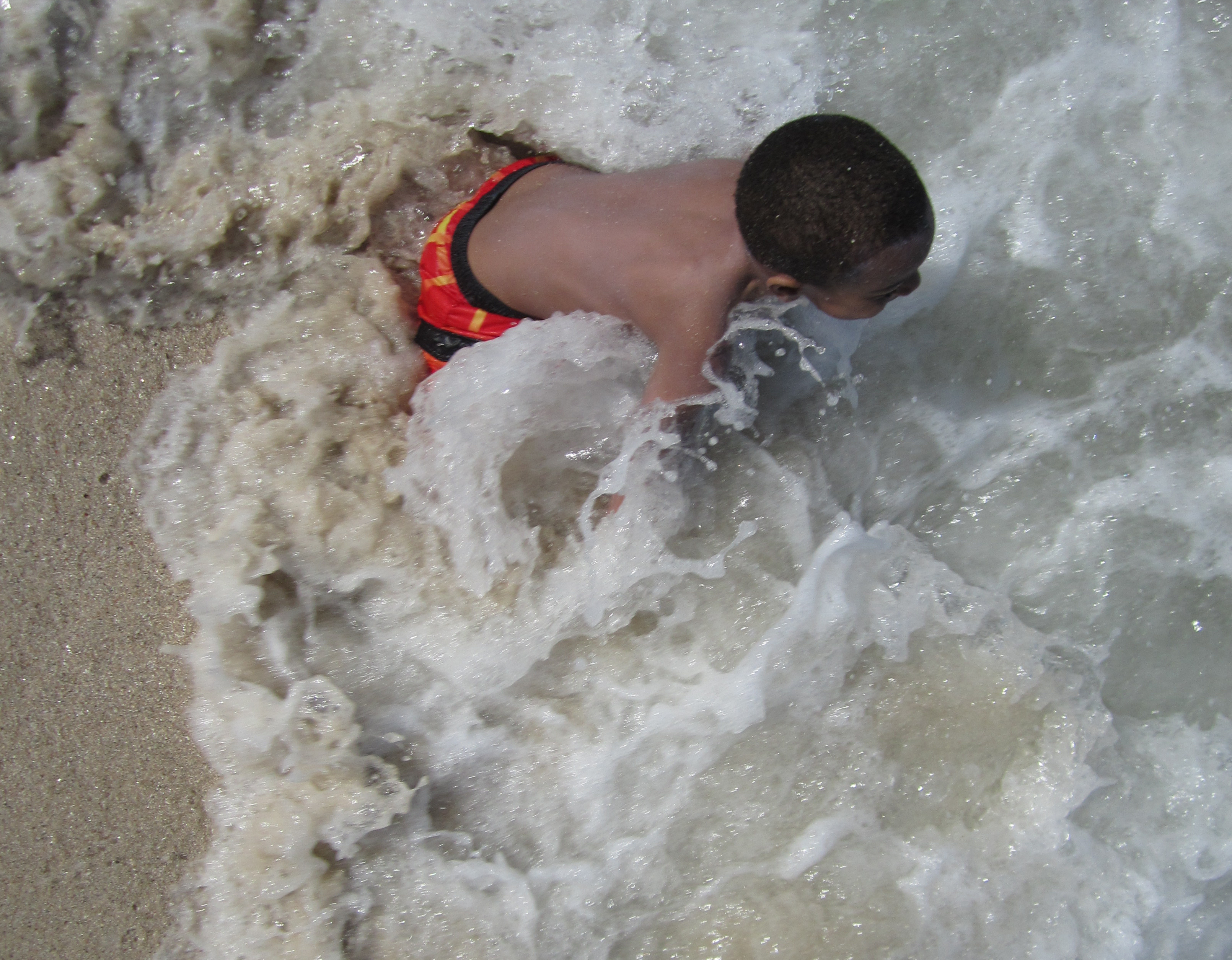 Child playing in gentle surf at the ocean beach.