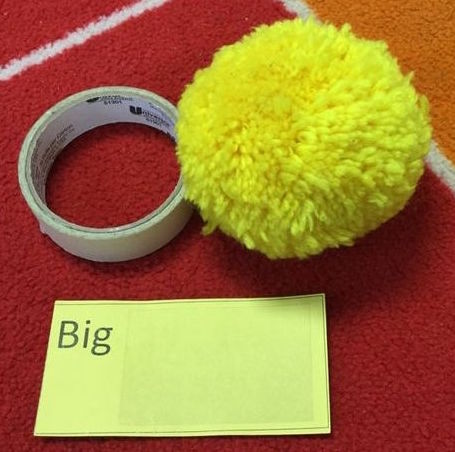 Two objects for rolling, labeled "Big": a roll of masking tape and a slightly larger yarn pom-pom.