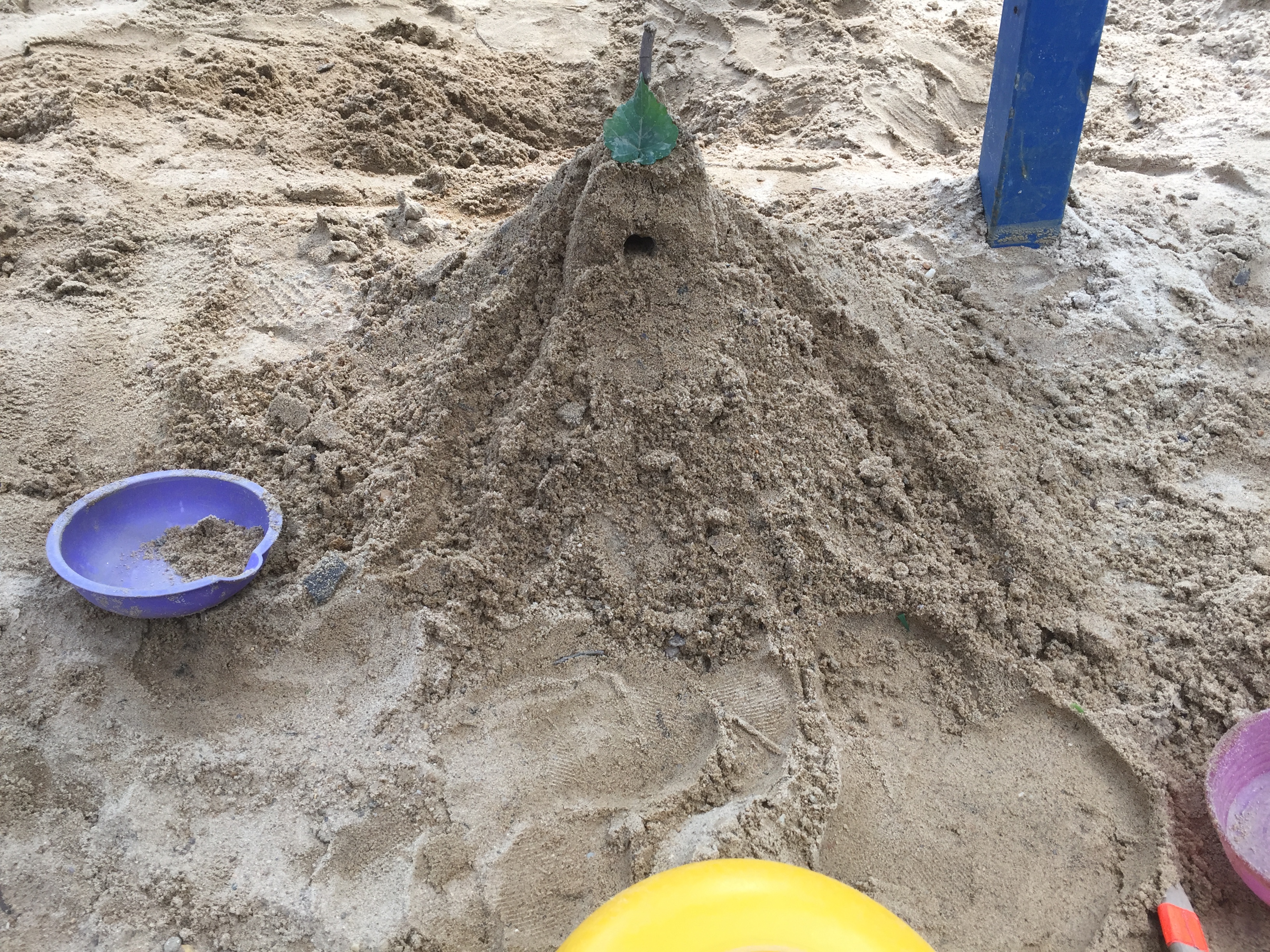 Sand "castle" with leaf at top.