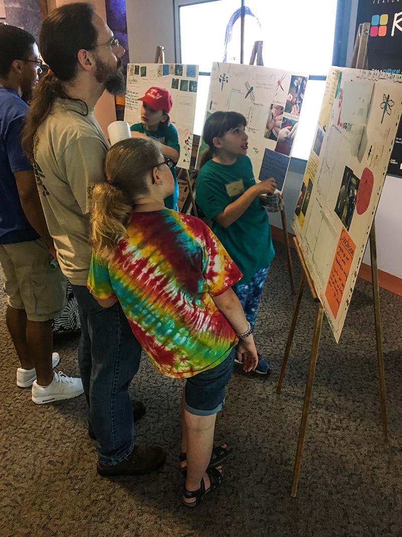 Dragonfly Detectives participants discuss their posters with BugFest visitors