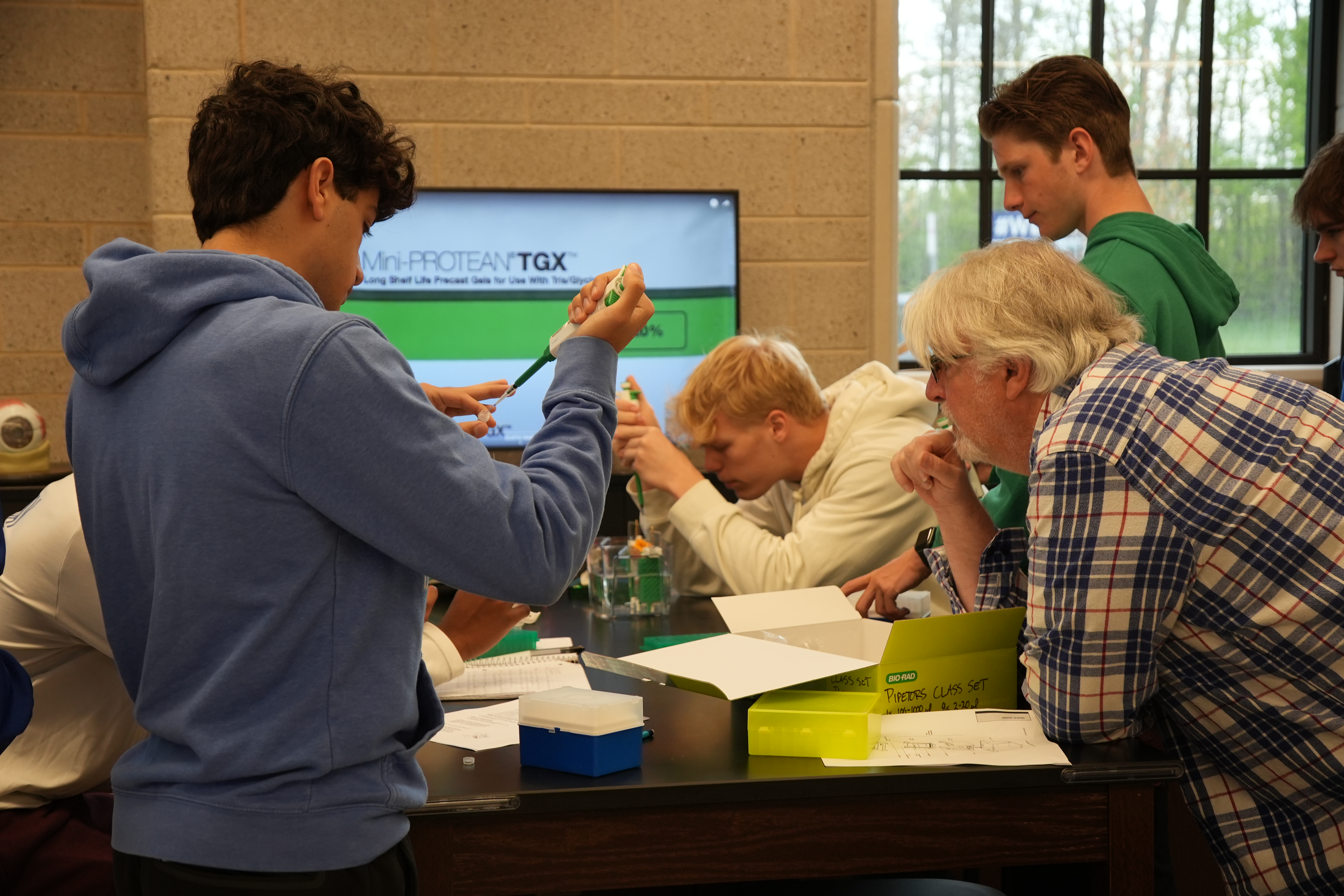 Catholic Central AP Biology students carefully load protein samples into gels during an SDS-PAGE lab, using electrophoresis to reveal molecular “fingerprints” of fish muscle proteins.