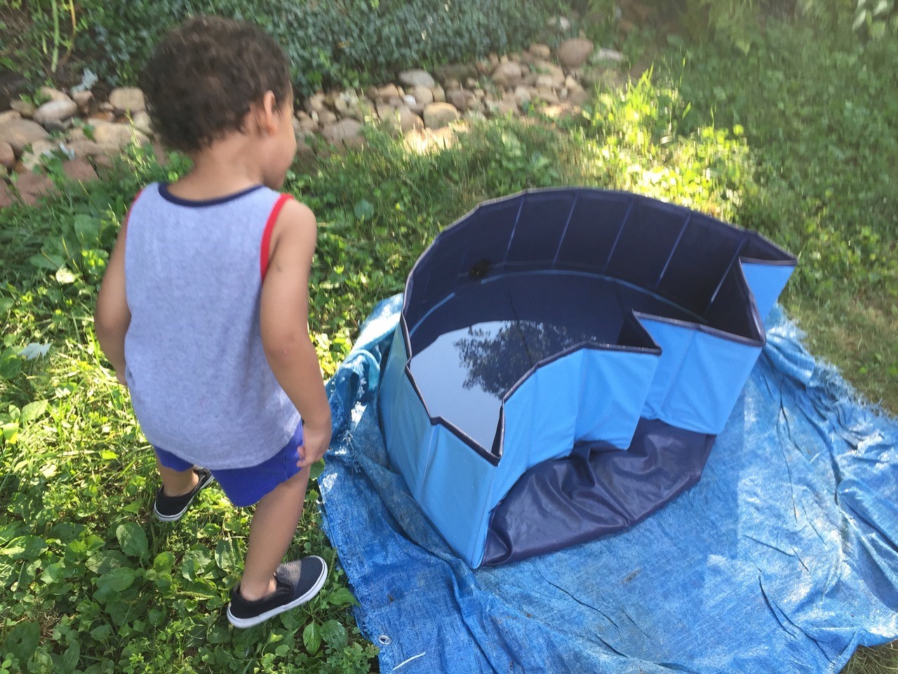 child looking down at part-way folded up pool