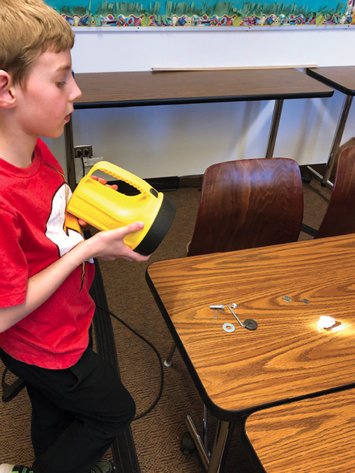 A student conducts a luster test with a flashlight.