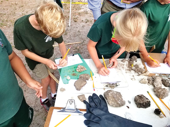 Students closely examine rocks. 