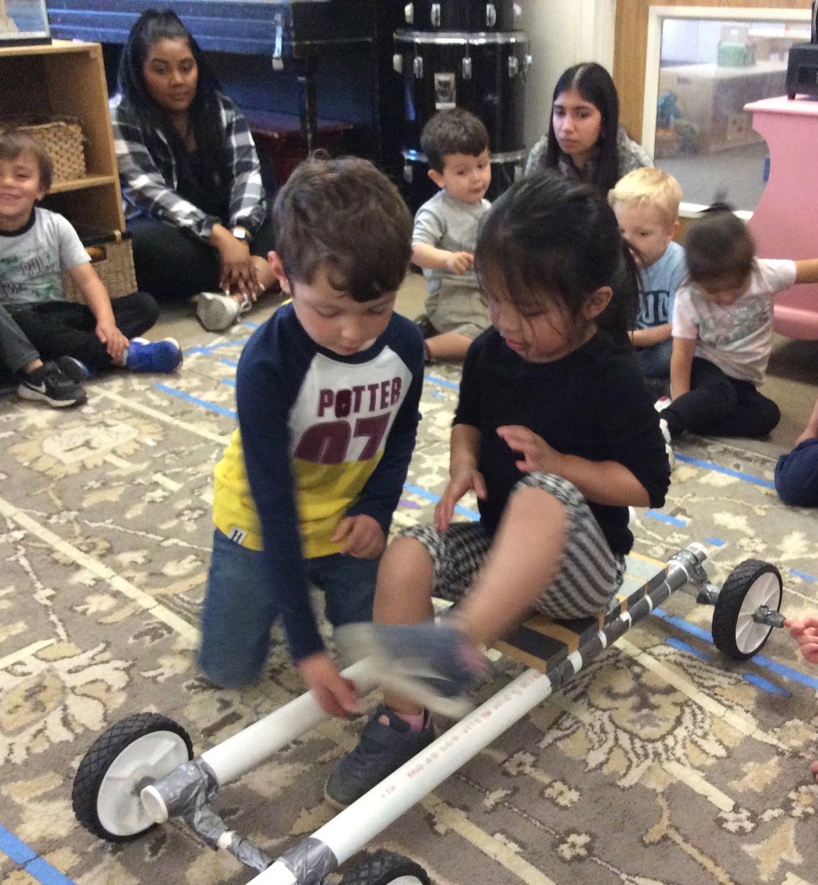 Students try the big car model in circle time.