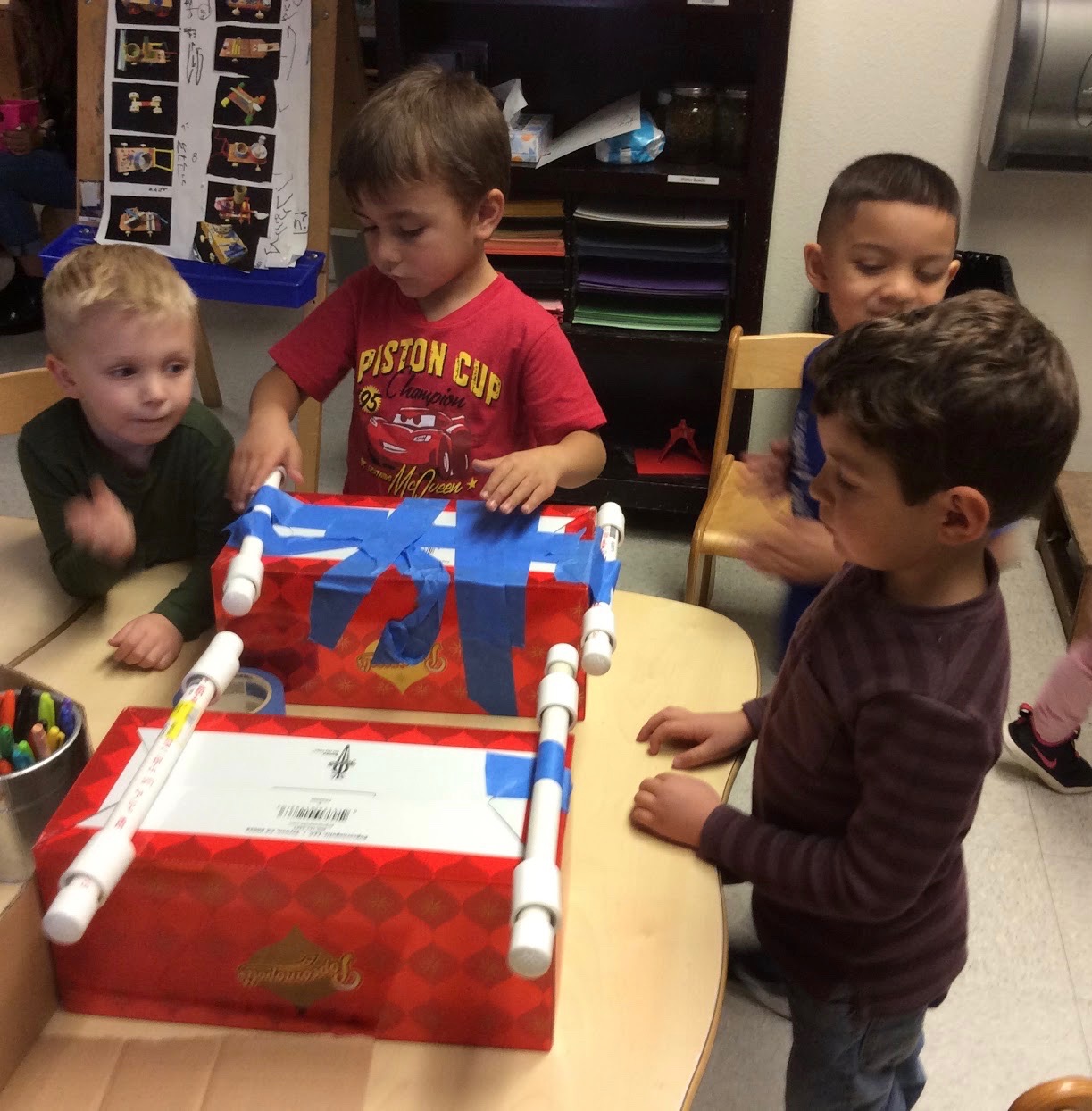 Children constructing two new cars with similar dimensions for further testing of their hypotheses.