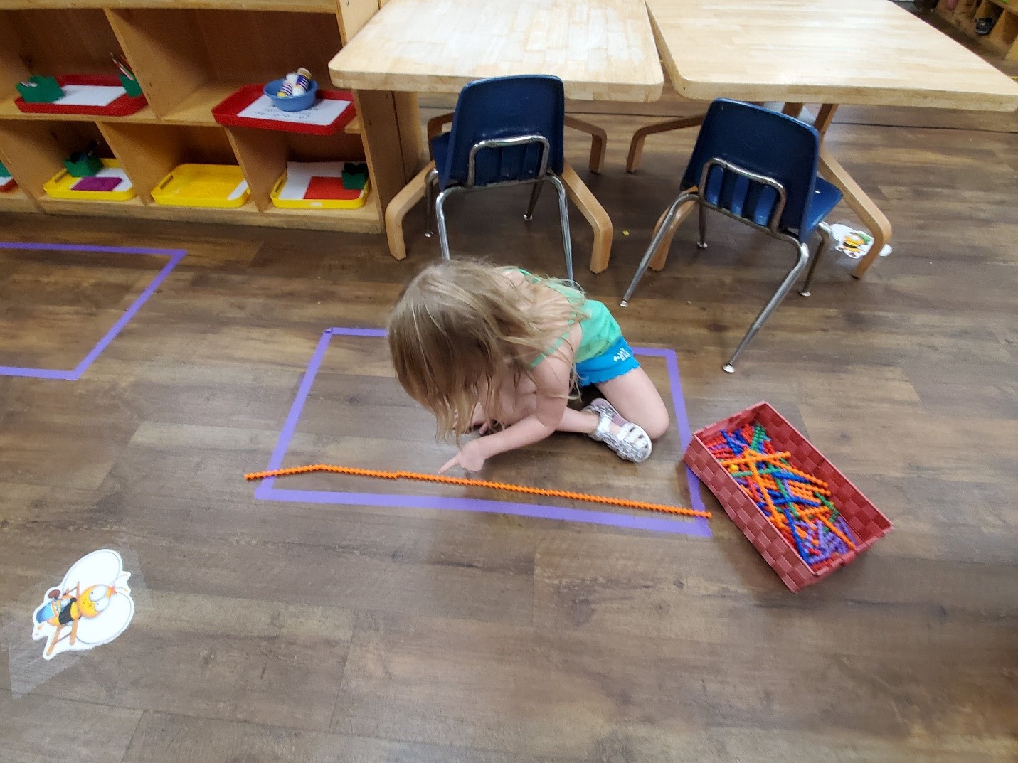 A learner uses manipulatives as a non-standard measurement tool.