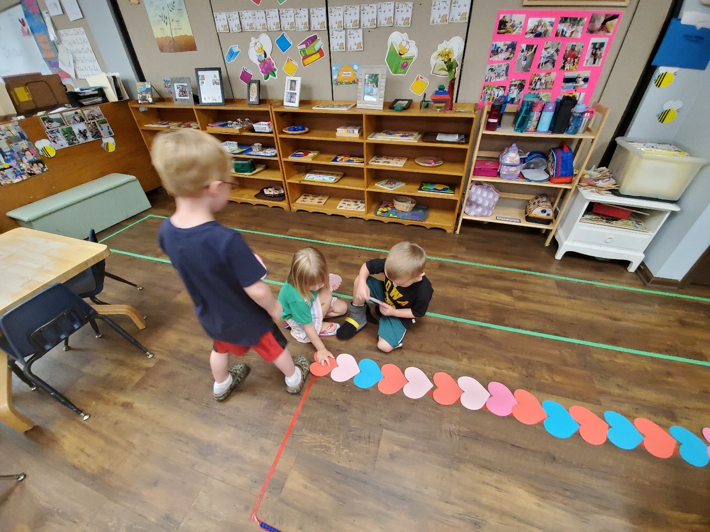 Students work collaboratively to count how many foam hearts it takes to equal the length of the velociraptor.