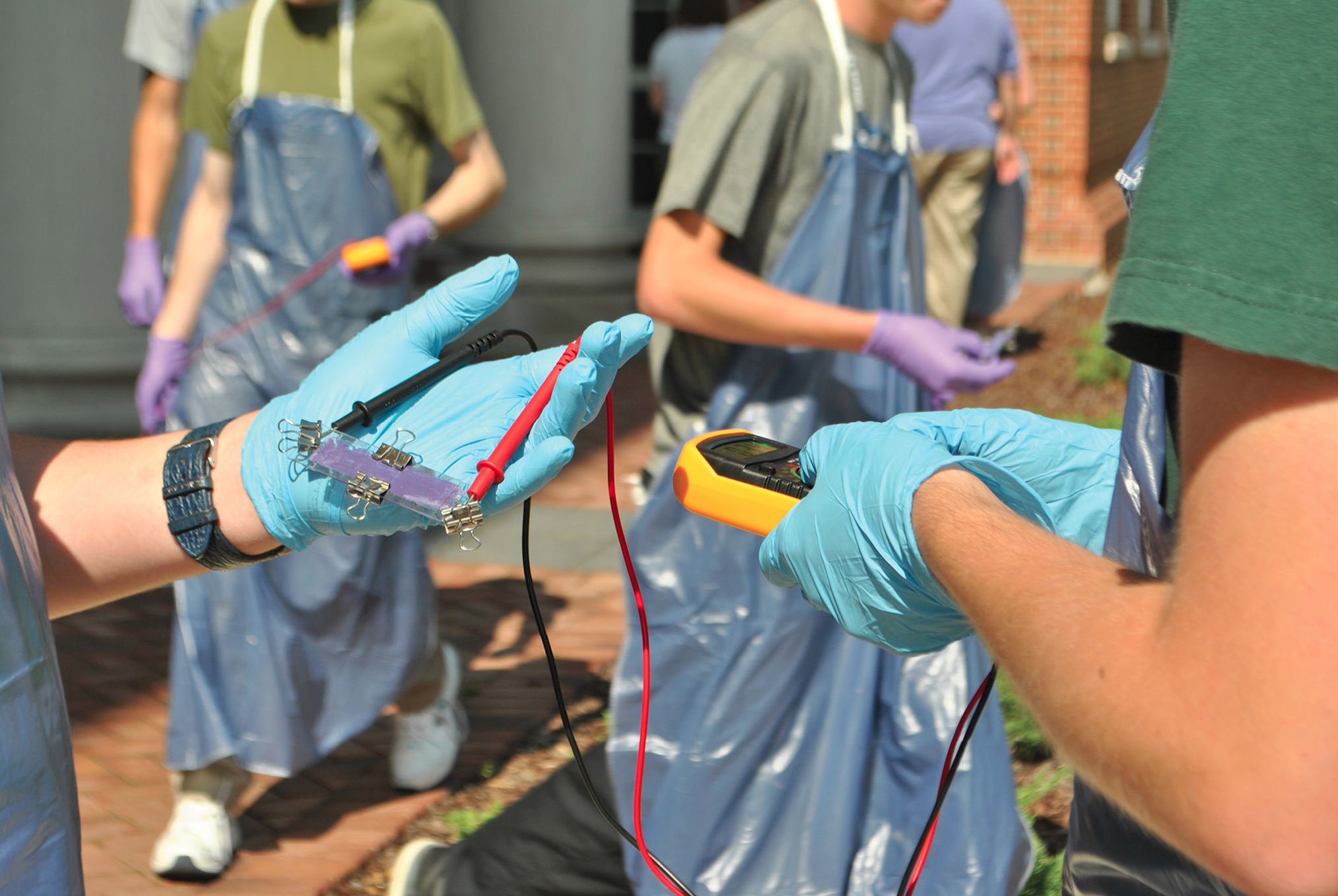 Figure 2 Students use a multimeter to test solar panels for energy efficiency.