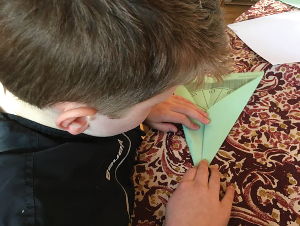 A student folds his airplane.