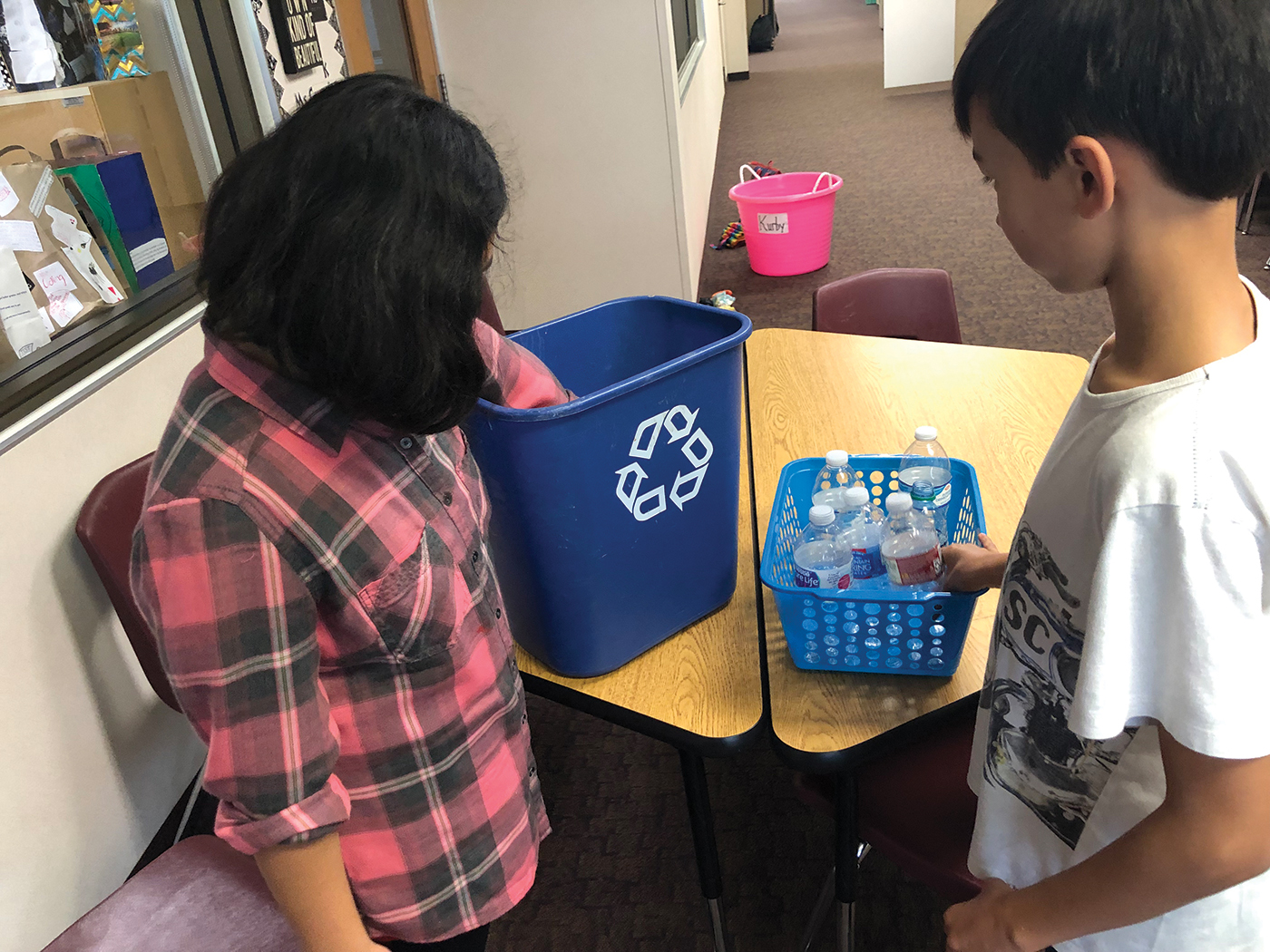 Students count the number of plastic bottles that have been discarded in classroom recycling bins during one school day.