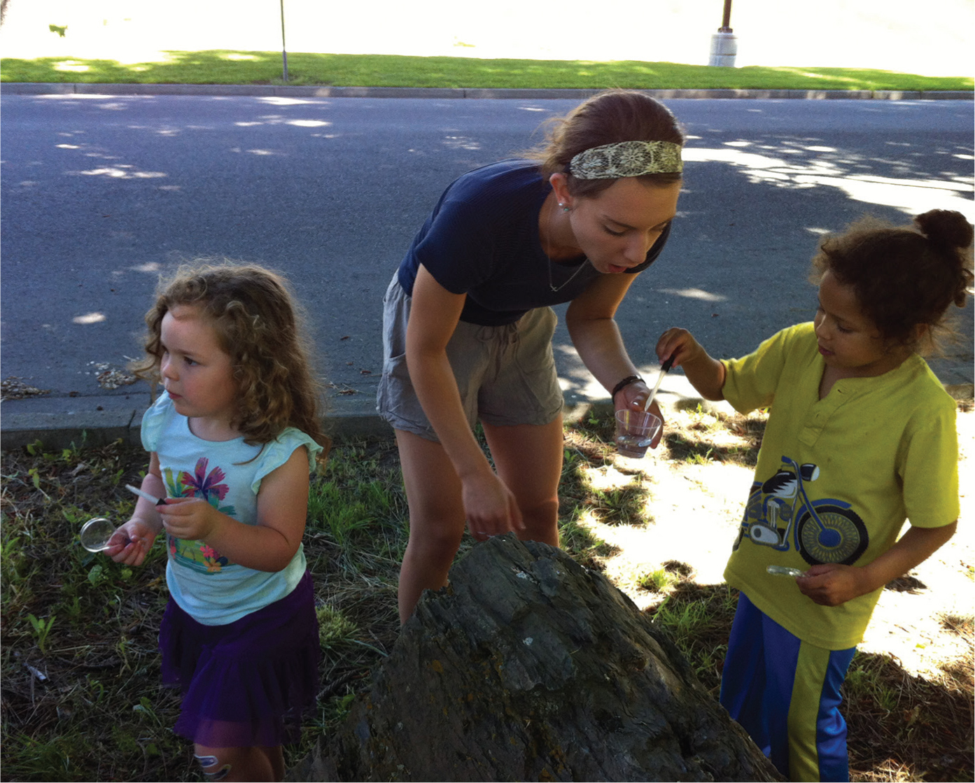 Students “Act Like Rain” on a rock in the park.