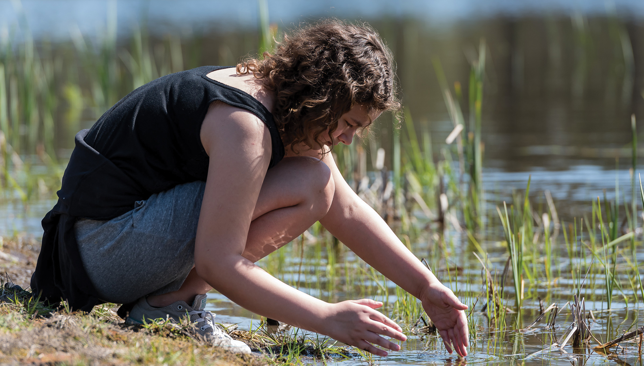 Middle school student examines the water for aquatic life (photo by Bridget Mayfield, Pescado Lago Studios).